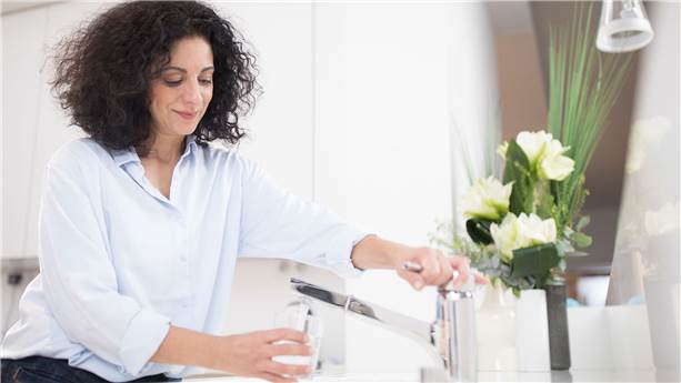Person filling a glass of water